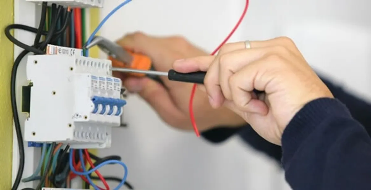 Electrician installing and adjusting circuit breakers in an electrical panel in Littleton, CO